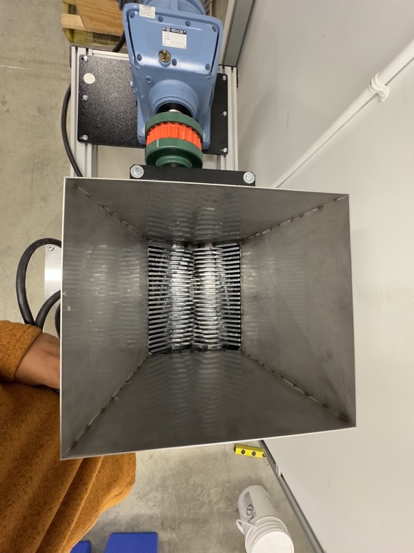 Looking down the hopper at the two interleaved blade stacks, with the reducer and jaw coupling behind.