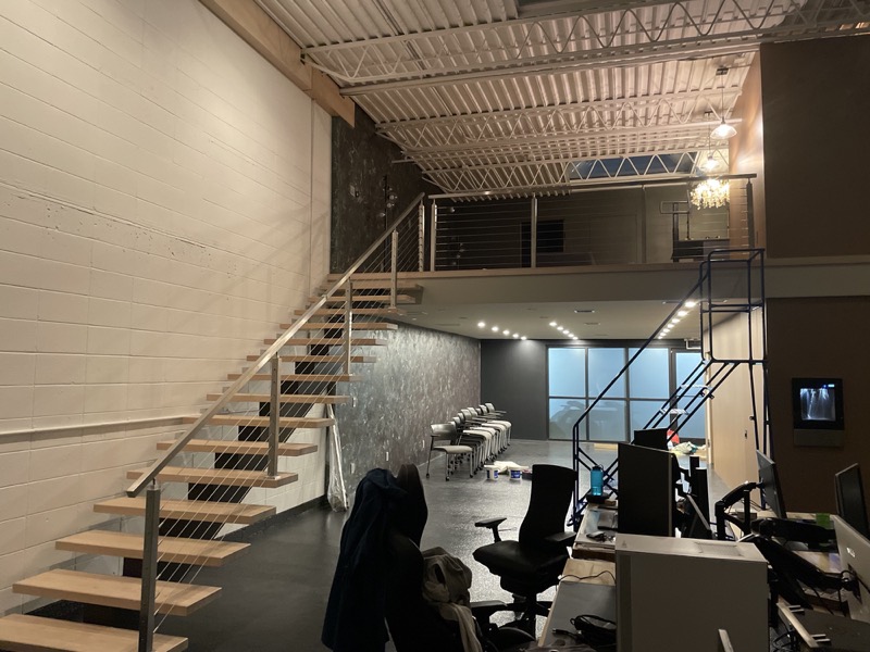 The finished bay, June 2025: the stair up to the office block's second floor and the open floor below.